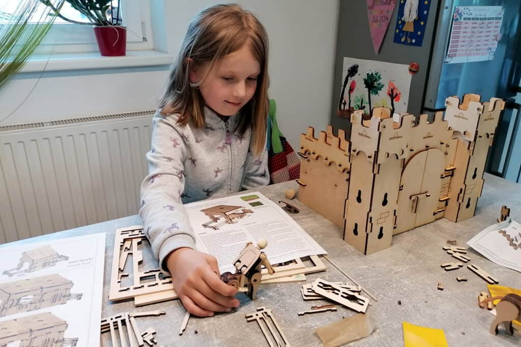 Spielzeugburg - Holzbausatz "Burgwacht" von WoodHeroes für Kinder ab 6 Jahre - Bild Einzelteile der Holzburg beim Aufbau