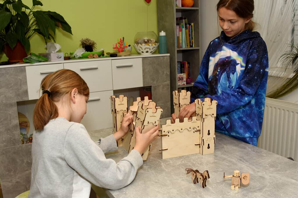 Children playing with wooden knight castle from the set castle guard - sustainable wooden toys from WoodHeroes