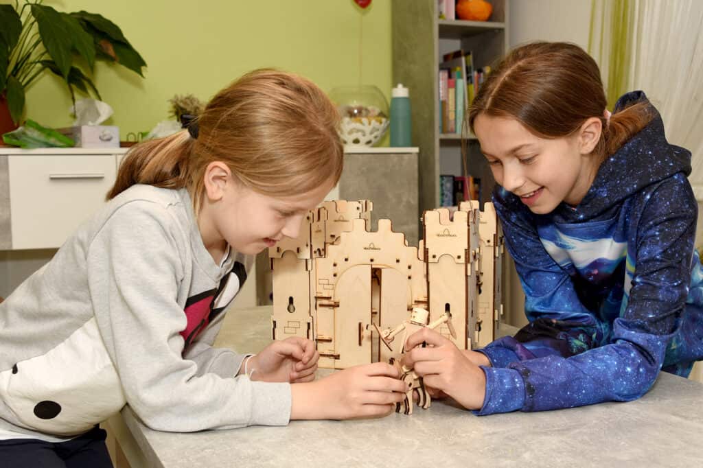 Girls play with wooden knight castle from set castle guard - sustainable wooden toys from WoodHeroes