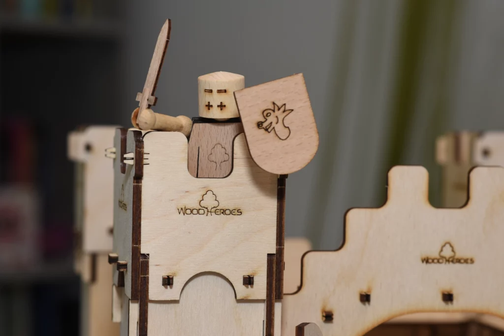 Die WoodHeroes Spielfigur aus Holz steht auf einem Turm der Holzritterburg.
